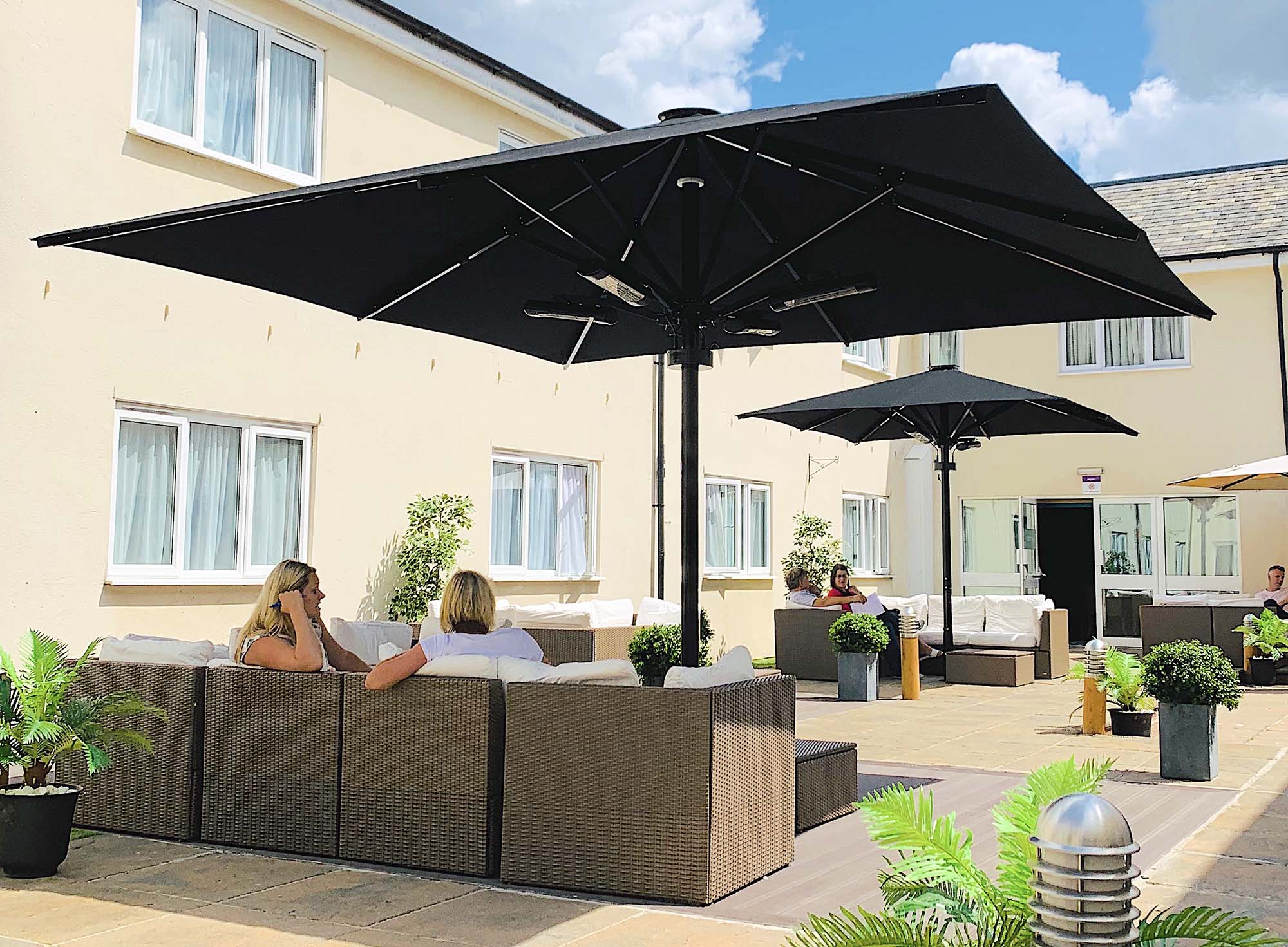 Two Umbrellas with outdoor seating area and customers