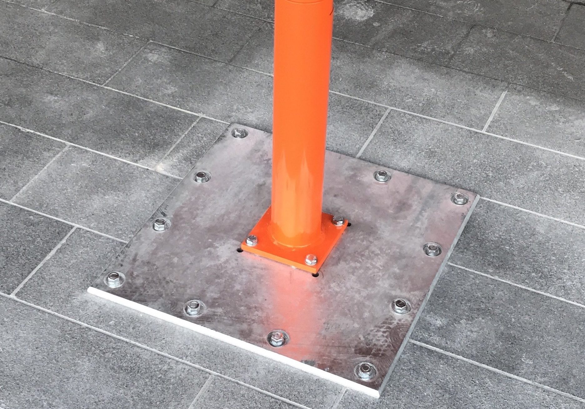 Orange RAL Umbrella pole bolted to ground via spreader plate